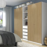 Light wood PAX wardrobe with open section beside bed.