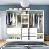 Modern bedroom closet with hangers, shelves, and drawers for organized storage.