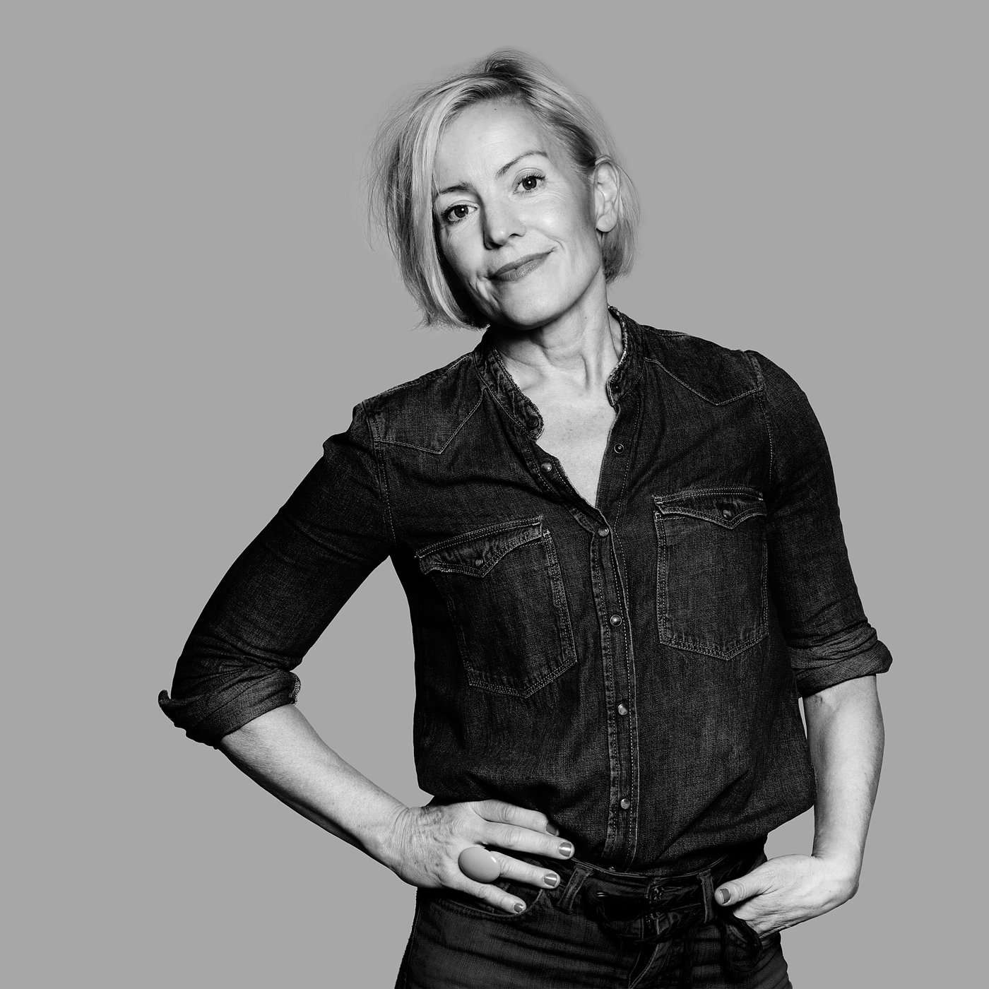 Black and white photo of the designer in casual denim attire posing confidently.