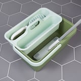 Green PEPPRIG cleaning bucket with handle, featuring slots for cleaning tools and a wavy bottom for mop cleaning.