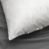 Image shows a single white pillow with ikea tag labeled PILSPINNARE. The pillow appears soft and plump, placed on a gray bedspread.