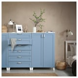 Blue PLATSA storage with drawers and cabinets. Modern design, white handles. Decor on top, next to bed.