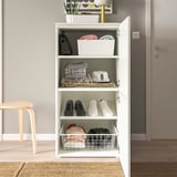 Open white PLATSA storage unit displaying shoes, folded clothes, and accessories on shelves, with additional storage baskets.