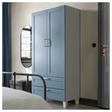 Blue PLATSA wardrobe with drawers and doors against bedroom wall.