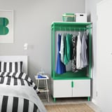 Modern bedroom with PLATSA storage & bed with striped pillows.