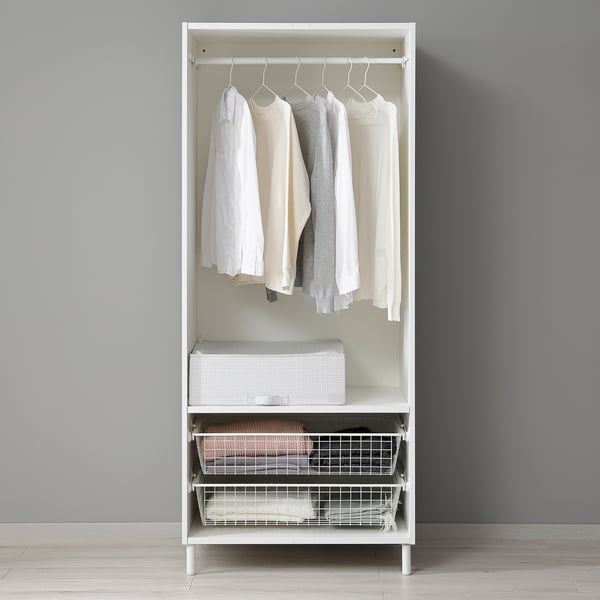A white PLATSA wardrobe with hanging shirts and baskets, storing clothes and accessories.