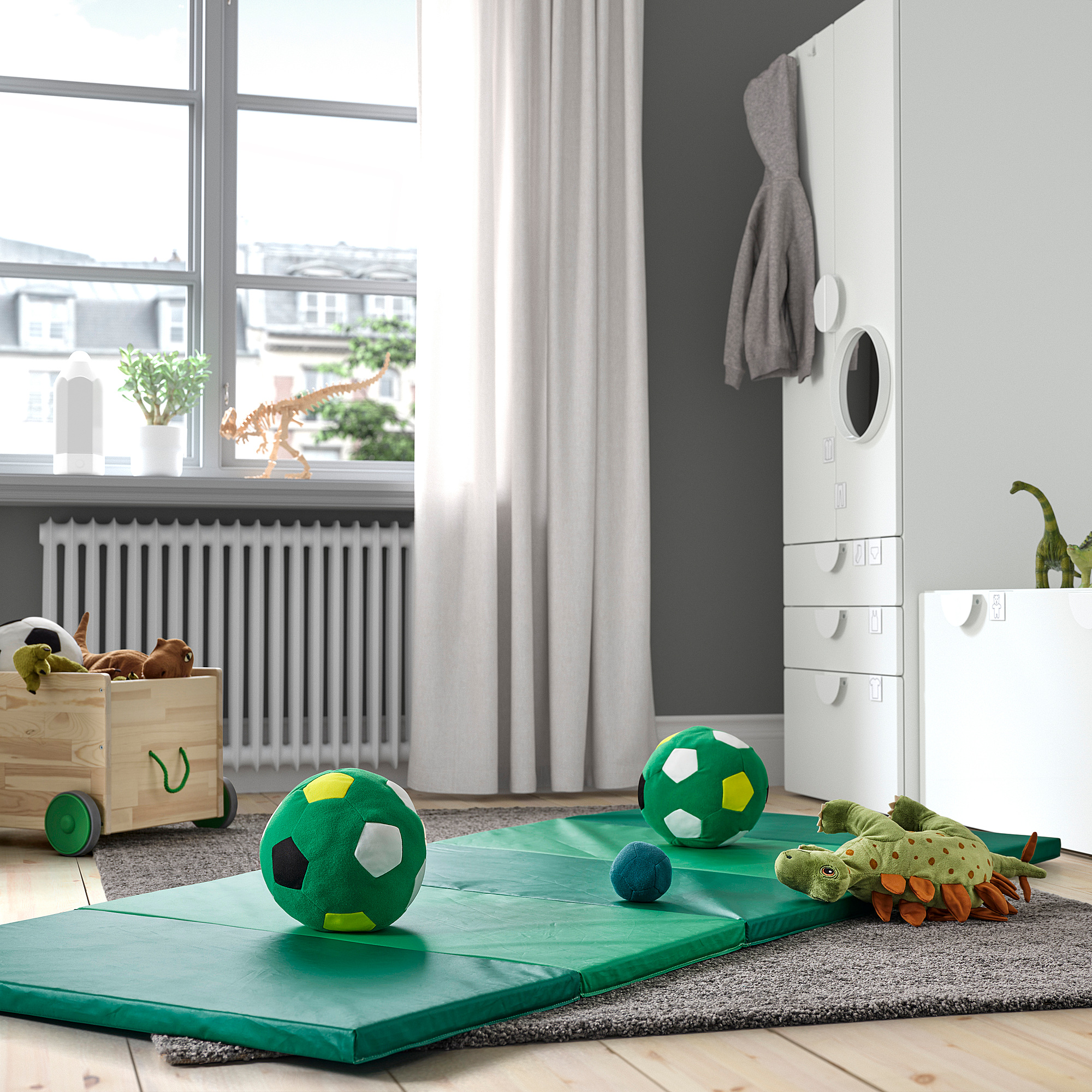 Green gym mat folded in playroom surrounded by toys. Alt