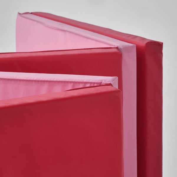 Stacked red and pink soft gym mats, ideal for kids play and safety.