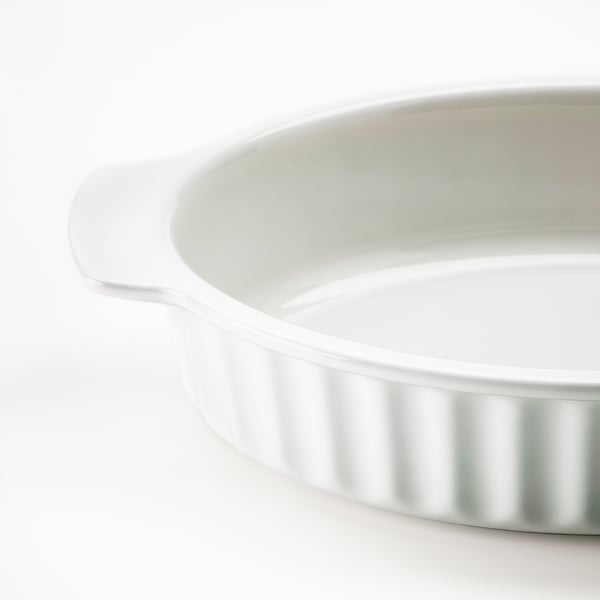 White, oval stoneware baking dish with side handles and ribbed design.