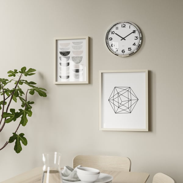 Modern dining room with round clock, art, and plant.