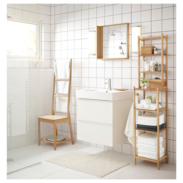 Minimalist white bathroom featuring RÅGRUND bamboo chair, shelf, and towel rack, offering multifunctional space-saving design.