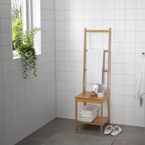 Wooden bathroom organizer with towel rack, shelf, and storage for towels and items, made from bamboo.