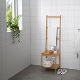 Wooden bathroom organizer with towel rack, shelf, and storage for towels and items, made from bamboo.