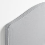Close-up of gray striped upholstered headboard, showing textured fabric and neat stitching.