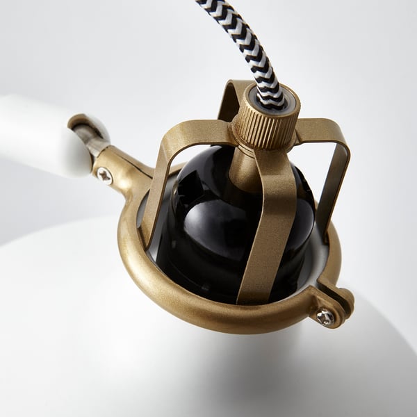 Modern golden lamp with black shade, adjustable joints, striped cable, sleek design.