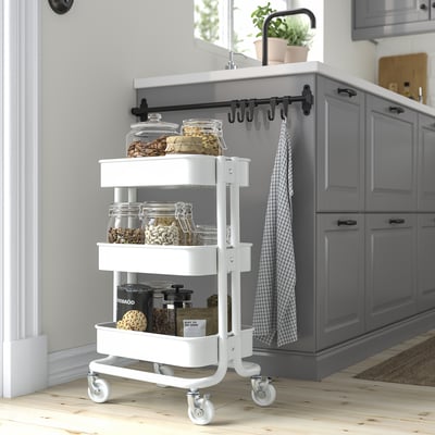 White RÅSKOG trolley with 3 shelves, small, fits under tables, holds jars.