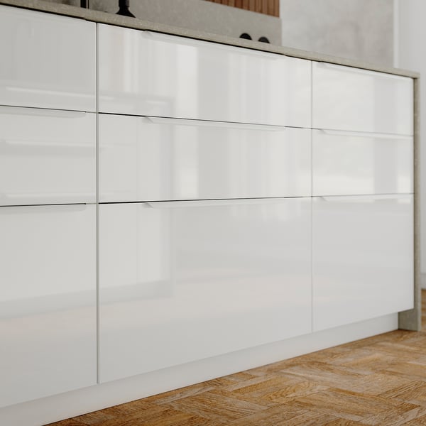 Modern white high-gloss kitchen cabinets with sleek, straight lines.
