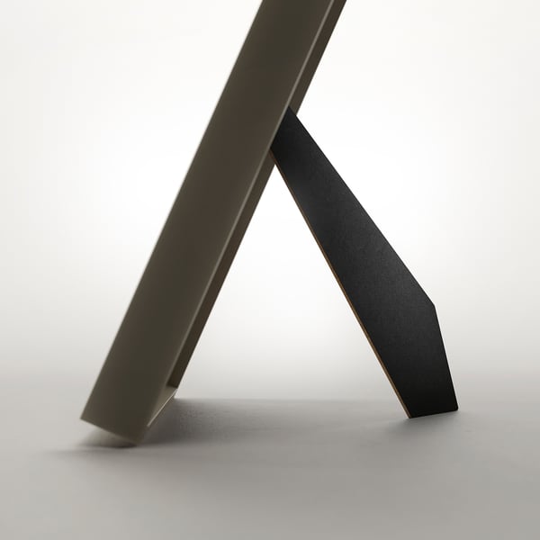 Modern picture frame, versatile and secure with protective plastic, stands or hangs, fits various sizes.
