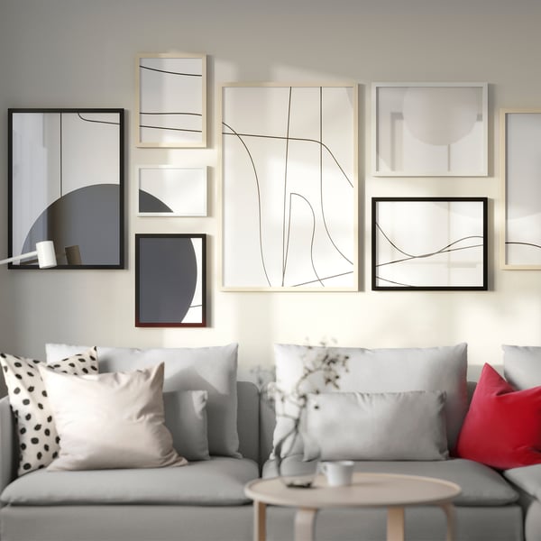 Modern living room with grey gallery wall, sofa, and coffee table with flowers.