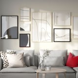 Modern living room with grey gallery wall, sofa, and coffee table with flowers.