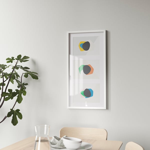 White ikea RÖDALM frame with abstract art above dining table.