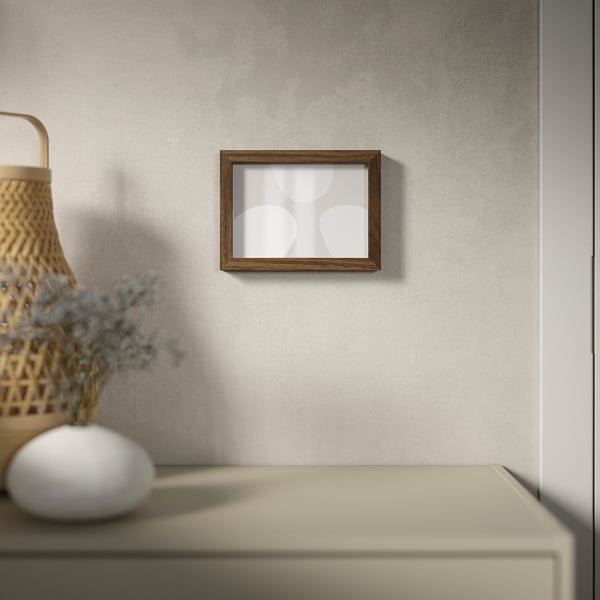 Wooden frame with abstract art on textured wall, dried flowers in wicker basket.