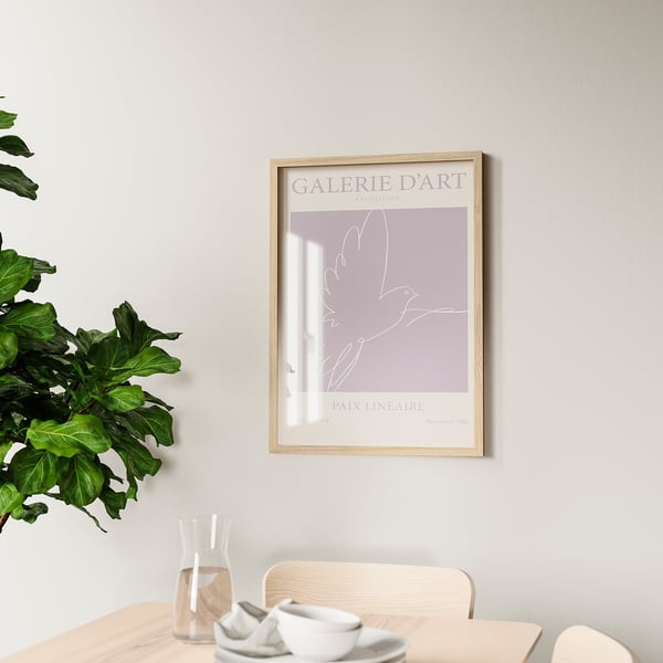 Framed artwork galerie dart hangs on wall above wooden table with cups and plant. Reinforced hooks on back for secure mounting.