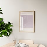 Framed artwork galerie dart hangs on wall above wooden table with cups and plant. Reinforced hooks on back for secure mounting.