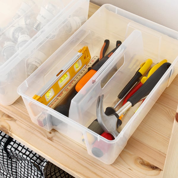 Clear plastic storage box organizer with compartments, holding tools, on wooden surface.