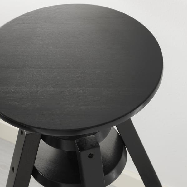 Round black stool with smooth, dark tabletop and sturdy metal legs, designed for durability and modern style.