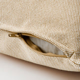 Beige cushion with textured fabric, open zipper revealing inner lining.