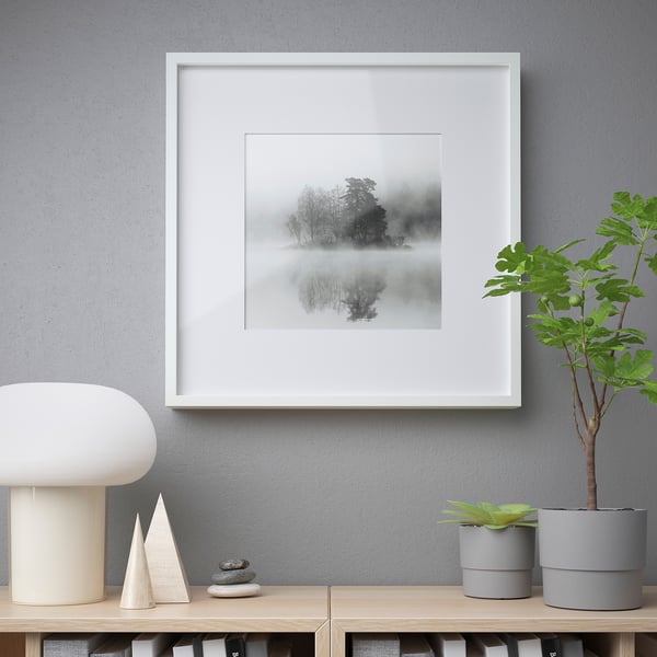 Modern living room with forest art, lamp, plants.