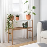 SATSUMAS plant stand with 3 potted plants. Natural wood, fits room with white couch & curtains.