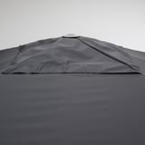 Gray fabric umbrella with sun protection, tilted to block rays.