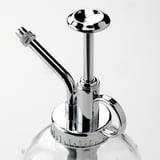 Elegant chrome plant mister with glass bottle, long spout, and trigger handle.