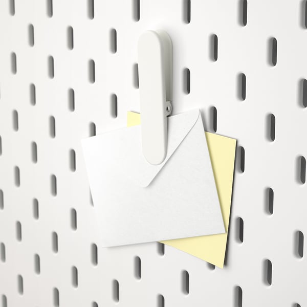 White pegboard with SKÅDIS hook holding letters.
