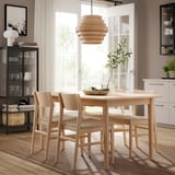 A modern light-brown wooden dining set with four chairs and an extendable table, inspired by scandinavian design.