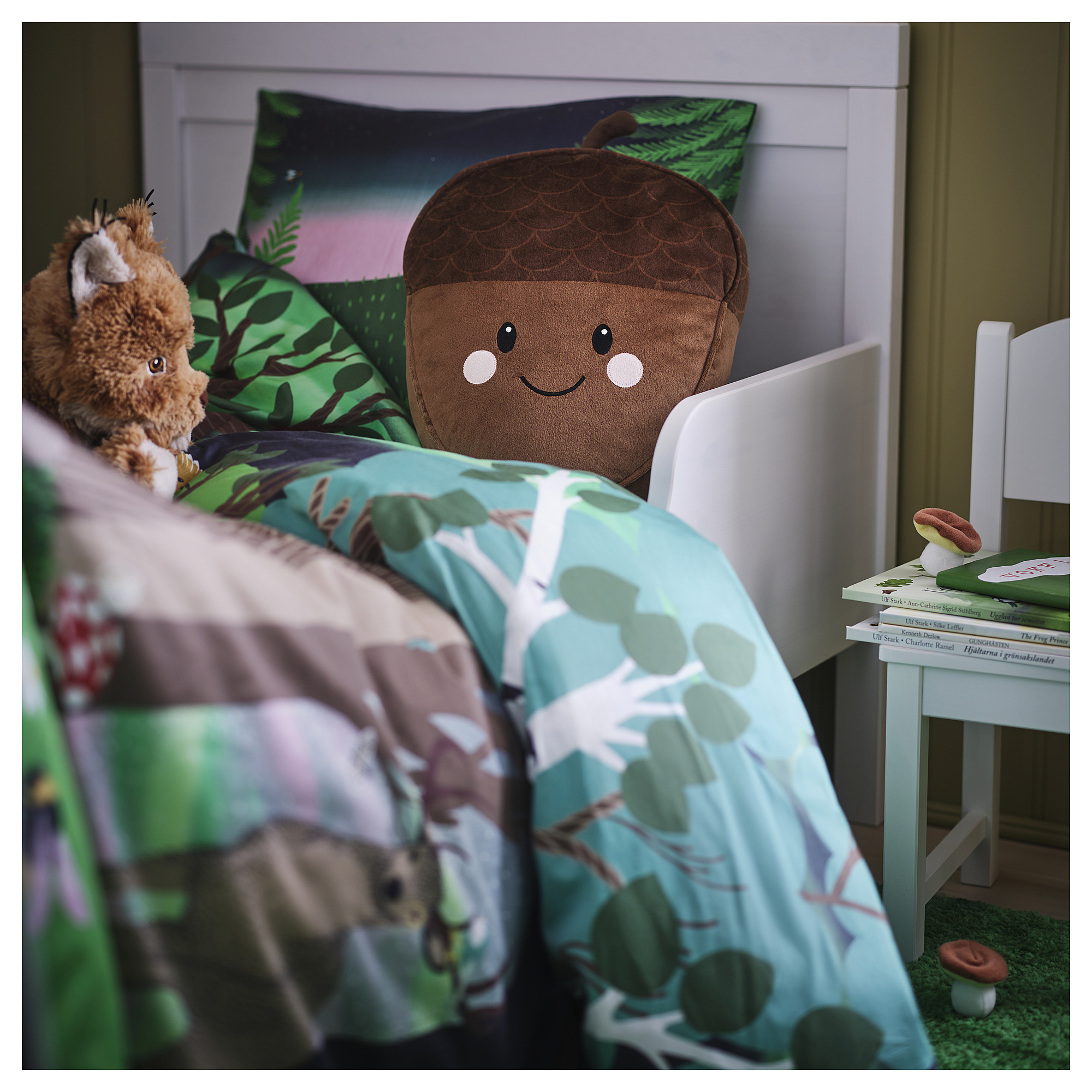 Childs cozy room with SKOGSDUVA pillow, horse toy, books, and green rug.