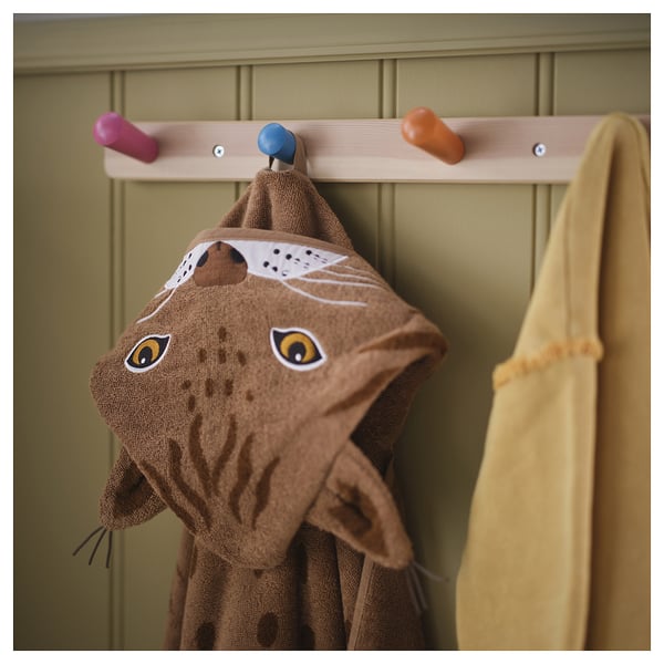 A fun lynx hooded towel hangs on a colorful hook, ready to warm and dry a child after a bath.