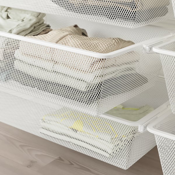 White mesh storage drawers organized with folded clothes on a wooden floor. Part of the boaxel wall-mounted storage system, great for saving space.