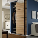 Modern bedroom with SKYTTA wardrobe, sliding doors, white shoe cabinet, black table, large mirror, blue-grey walls.