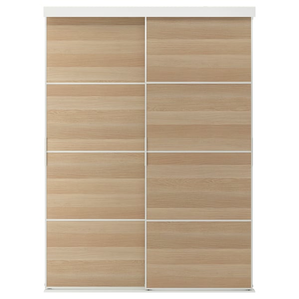 A SKYTTA light wooden wardrobe with sliding doors, framed in white.