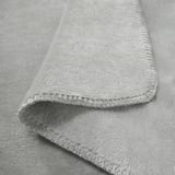 A plush, light grey throw blanket with soft, folded edges and a velvety texture. Recycled polyester material, showcasing luxurious feel and quality.