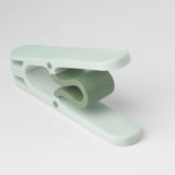 Light green plastic clothes peg with wide opening, designed for easy handling and durable use.