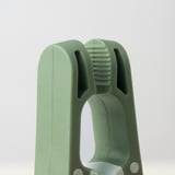 Green plastic clothes peg with a wide opening for easy use and durability.
