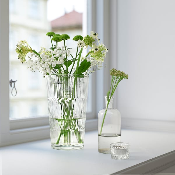 Flower vase, glass with white flowers, small buds on side.