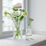 Flower vase, glass with white flowers, small buds on side.