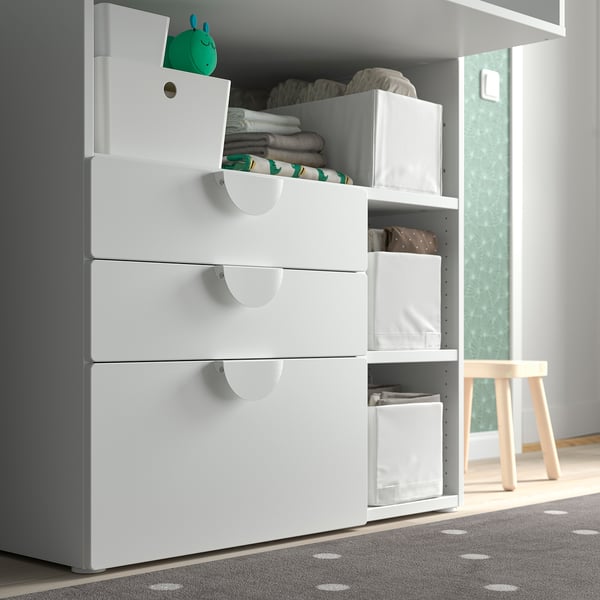 White childs storage chest with drawers and bins, organized with blankets and clothes, part of the SMÅSTAD series.
