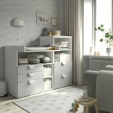 SMÅSTAD changing table & storage in nursery. Light grey, white, multi-shelf & drawer units. Cloud wallpaper, grey chair, toy, plant.
