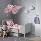 Childs room with cloud walls, SNÖFINK canopy, gray bed, toys.